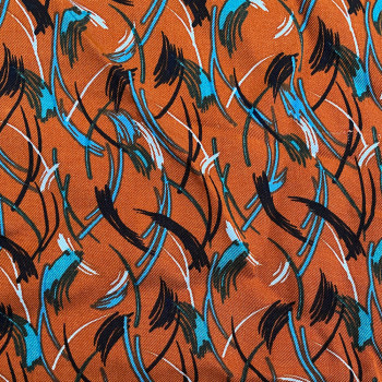 Twill fabric with feathers print on rust background 100% viscose