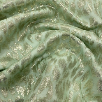 Gold metallic silk jacquard fabric on pale green chiffon background