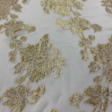 Metallic silk jacquard flowers on a gold ivory muslin background Metallic silk jacquard flowers on a gold ivory muslin background