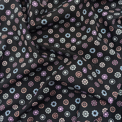 Cotton poplin fabric with circular patterns on a black background