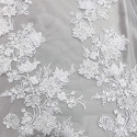 Optical white beaded embroidered tulle fabric with floral reliefs