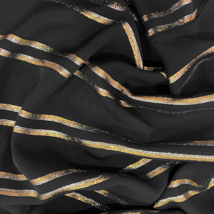 Metallic striped chiffon fabric on black background