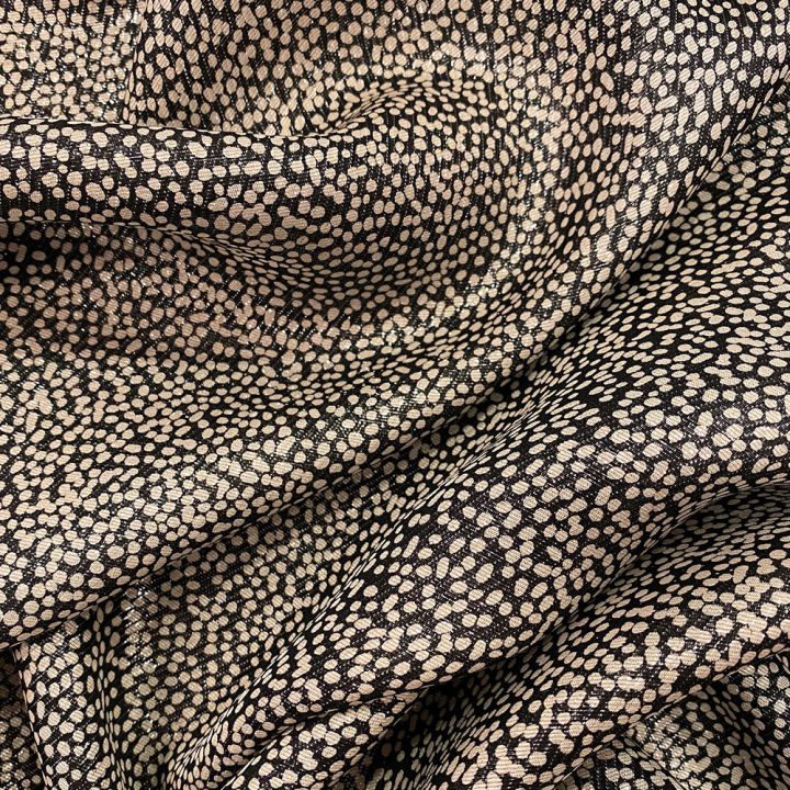 Silk lamé fabric with polka dots on a black background