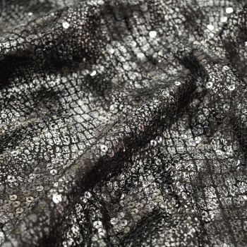 Silver sequin fabric on black crocodile print background