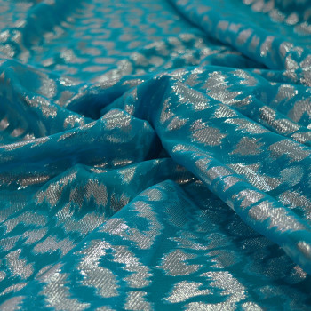 Silver metallic silk jacquard fabric on turquoise blue chiffon background